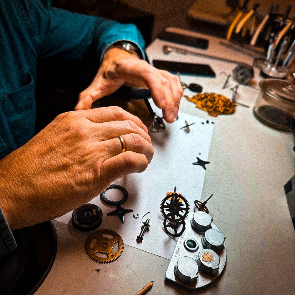 Urmakerens hender i arbeid ved benken